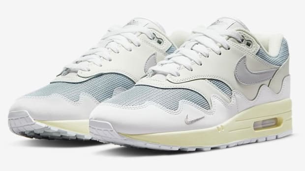View of white and grey Nike Air Max 1 shoes.